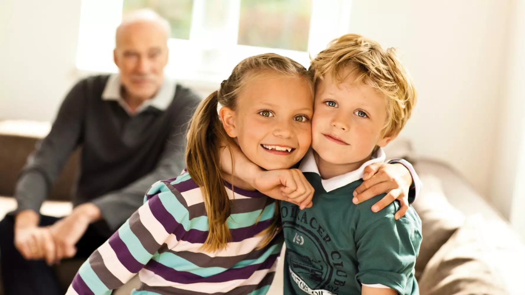 Geschwisterkinder mit ihrem Großvater