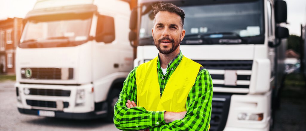 Fuhrpark und Gewerbeschutzbrief Mann am Lkw freut sich über den Gewerbeschutzbrief