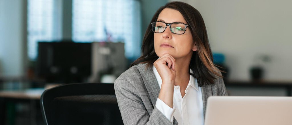 Geschäftsfrau am Laptop denkt über Pensionsmanagement nach. Geschäftsfrau am Laptop denkt über Pensionsmanagement nach.