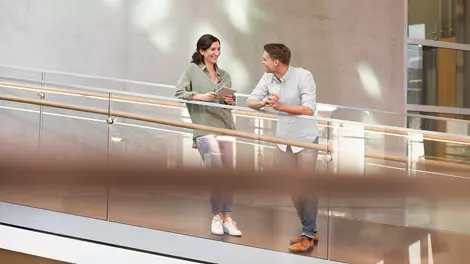 2 Personen stehen in der LVM-Zentrale und unterhalten sich