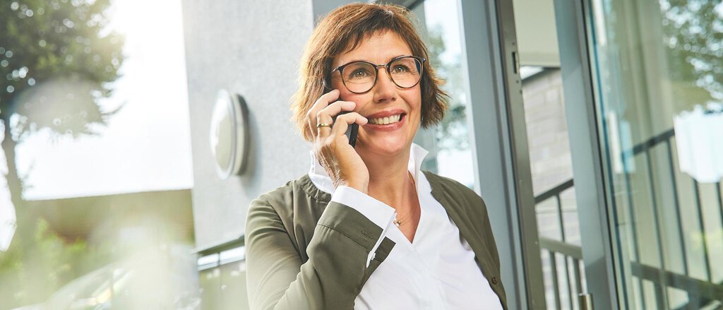 Eine Familie steht sorgenfrei vor Ihrem Haus dank der Immobilien-Rechtsschutzversicherung.