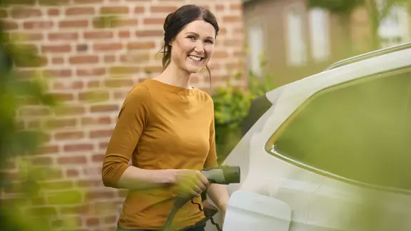 Eine Frau lädt ihr E-Auto
