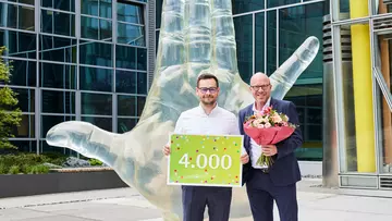 Personalchef Guido Hilchenbach (r.) begrüßt den 4.000. Mitarbeitenden in der LVM-Zentrale in Münster. (Foto: LVM Versicherung/Bernd Schwabedissen)