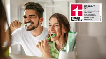 Mann und Frau die vor einem Spiegel Zähne putzen, sowie Stiftung‑Warentest‑Siegel: LVM‑Zahnzusatzversicherung ZahnPremium mit der Note Sehr gut (0,7) (07/2025).
