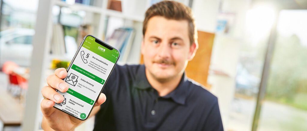 Eine Frau zeigt auf ihrem Smartphone die App der LVM Versicherung, mit der sie die Rechtsschutz-Services der LVM in Anspruch nehmen kann.
