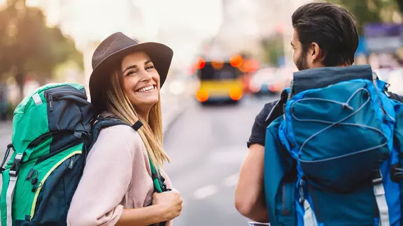 Junge Frau mit Rucksack und Auslandskrankenversicherung. 