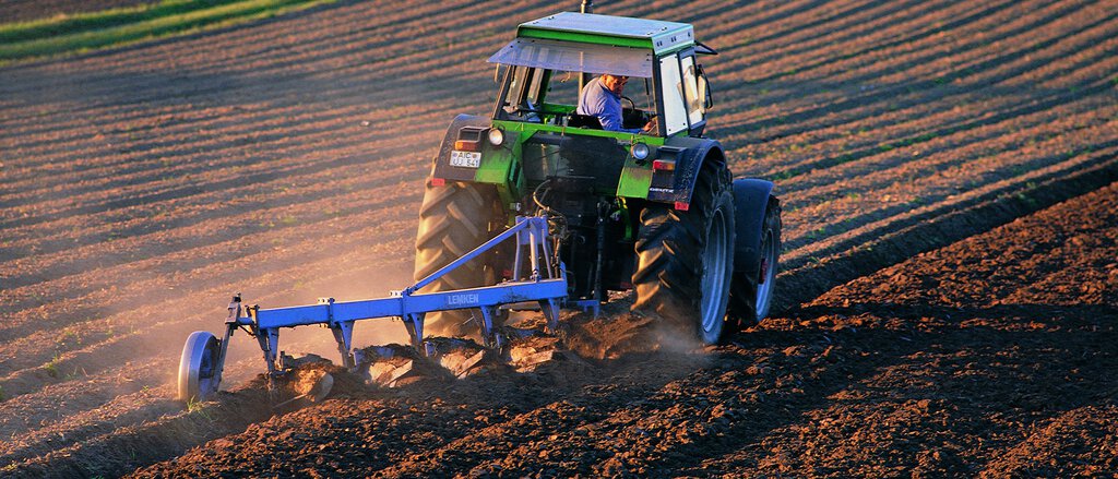 Bauer pflügt das Feld mit seinem Traktor 