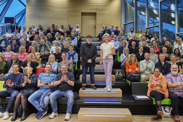Joey Kelly steht neben einer Moderatorin auf einer Treppe im Publikum. 