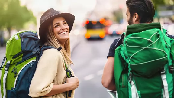 Junge Leute sind nach der Schulzeit mit Rucksack auf Reise.