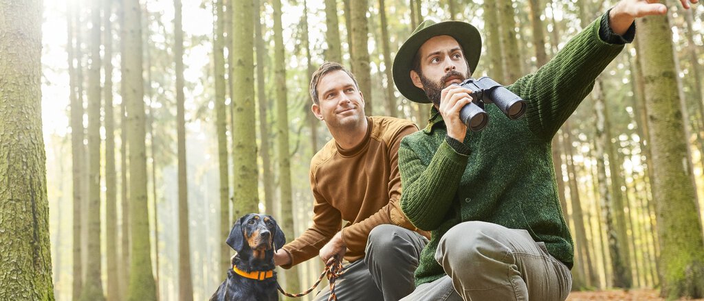 Jagdhaftpflichtversicherung Zwei Männer mit Hund auf der Jagd im Wald