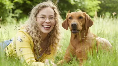 Junges Frau mit Hund auf Wiese
