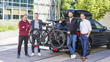 Vertreter von LVM und travelträger vor einem Auto mit Fahrradanhänger. LVM und travelträger bauen ihre bestehende Partnerschaft weiter aus (v. l.): Philipp Güntzel, Andreas Laukötter, Mark Sander (Co-Gründer und CEO von travelträger) und Christopher Thale (LVM-Konzernentwicklung). Foto: LVM Versicherung/Bernd Schwabedissen