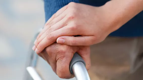 Händchenhalten während Gehhilfe genutzt wird