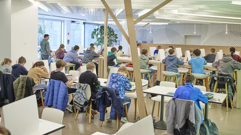 Mehrere Kinder lösen Matheaufgaben, sitzen am Tisch und denken nach