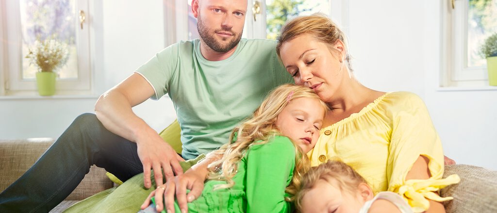Risikolebensversicherung - Paar umarmt sich Junges Paar kuschelt mit seinen Kindern